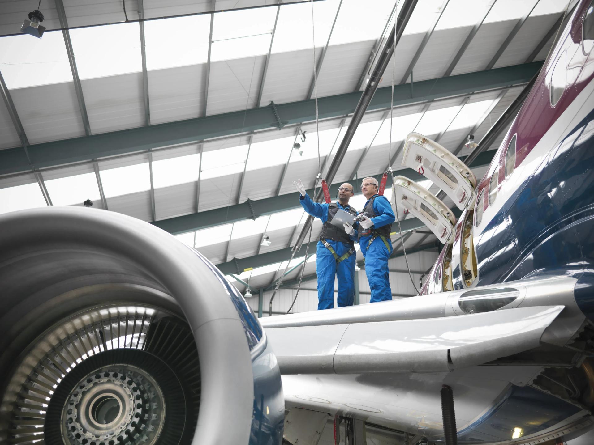 Homens inspecionando avião